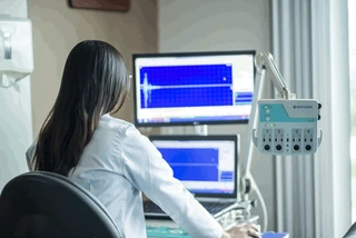 Woman in medical clothes working at a computer in a hospital