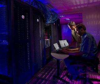 Two people working in a computer network room